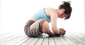 Woman sitting in yoga position stretching back