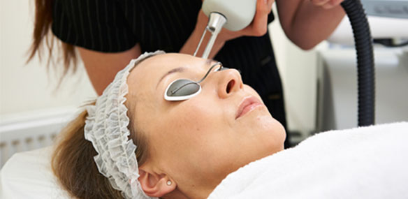 Woman receiving laser light therapy on face