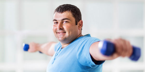 Overweight man using free weights 