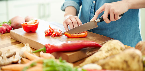 Close up of woman chopping vegetables in kitchen