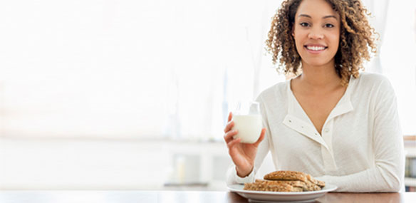 African-American woman sitting at table eating breakfast
