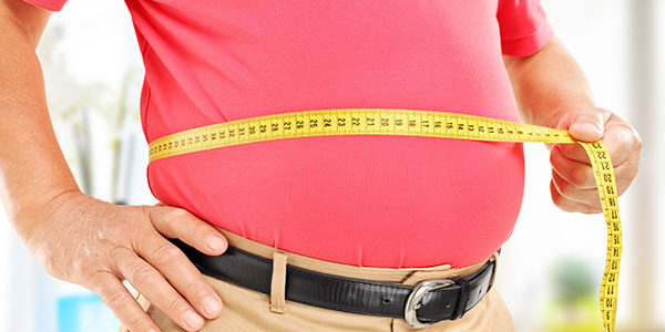 overweight man measuring waist
