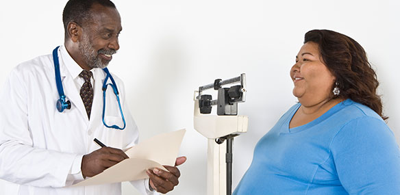 African-American doctor weighing overweight woman