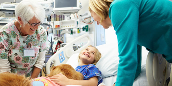 Therapy dog consoling child in hospital