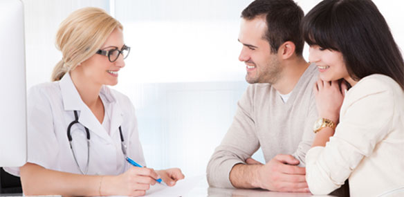 Happy couple in discussion with doctor