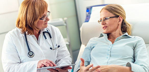 Mid adult woman discussing with female doctor