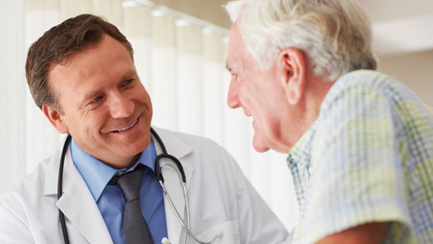 Male doctor in discussion at doctor's office with elderly male patient