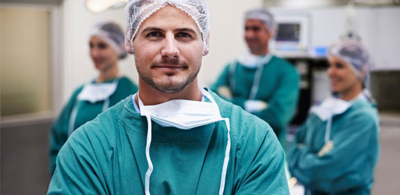 Male surgeon in forefront with surgical team in background