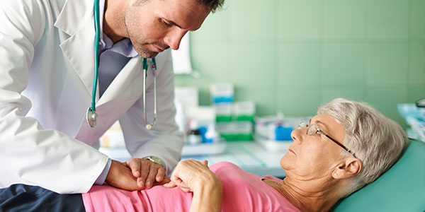 Doctor examining senior woman's stomach