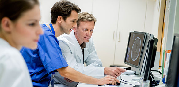 Two doctors discussing ct head scan on computer screen