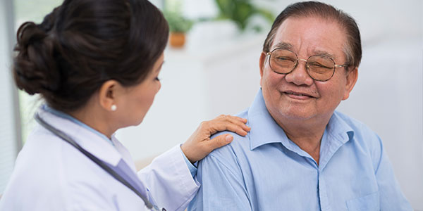 Asian doctor comforting senior asian male patient