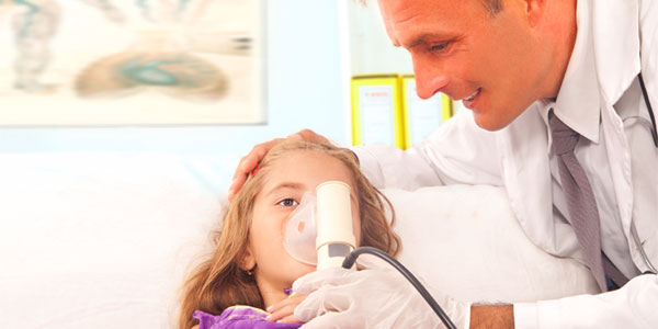 Doctor giving girl breathing treatment in doctor's office