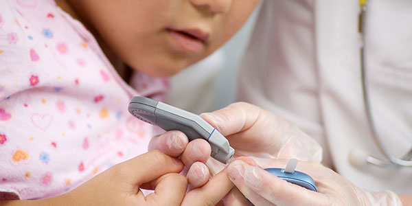 Doctor measuring child's blood sugar