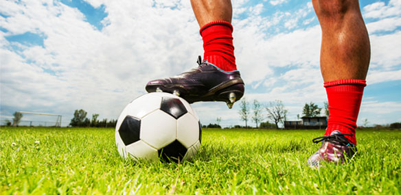 Close up of African-American man with foot on a soccer ball
