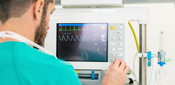 Doctor adjusting heart monitor machine