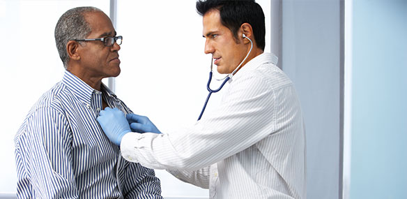 Male doctor listening to male African American patient's chest