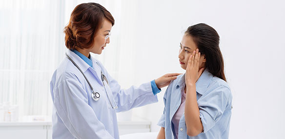 Asian doctor and female patient with headache