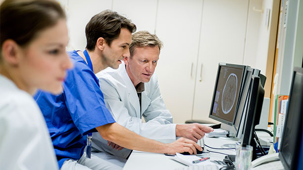 Doctors discussing head ct scan on computer screen