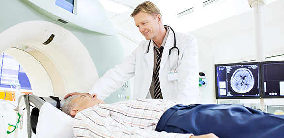 Male patient getting MRI with doctor standing by