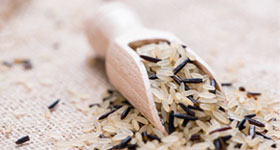 Close up of uncooked rice on a wooden spoon