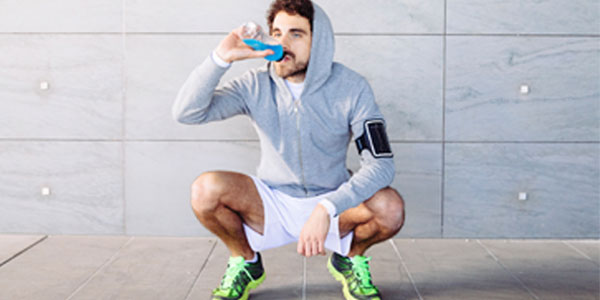 Man drinking energy drink after a run
