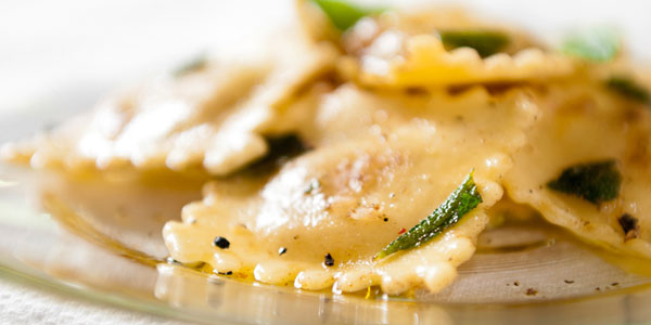 Close-up of a serving of ravioli coated in spices and herbs.