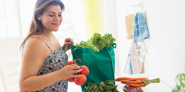 Woman unbagging fresh produce