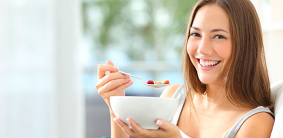 Young woman eating bowl of cereal