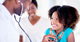 African American girl getting checkup by pediatrician