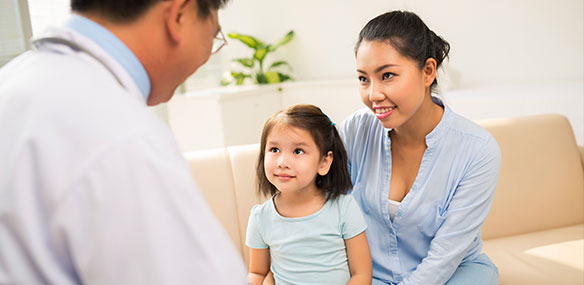 Asian male doctor talking to Asian mother and daughter