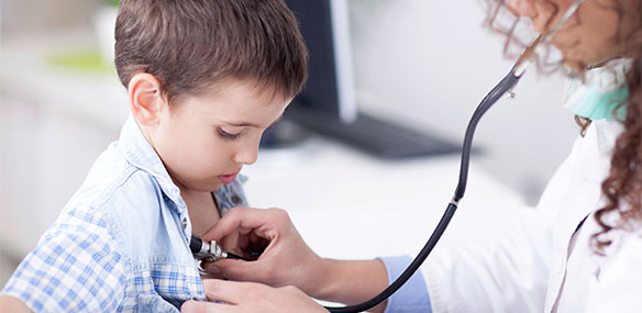 Doctor listening to little boy's heart
