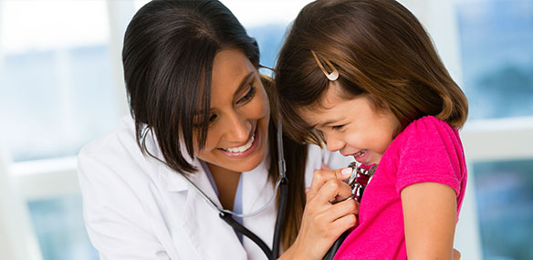 Indian female doctor checking heartbeat of little girl