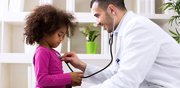 Pediatrician listening to girl's heartbeat