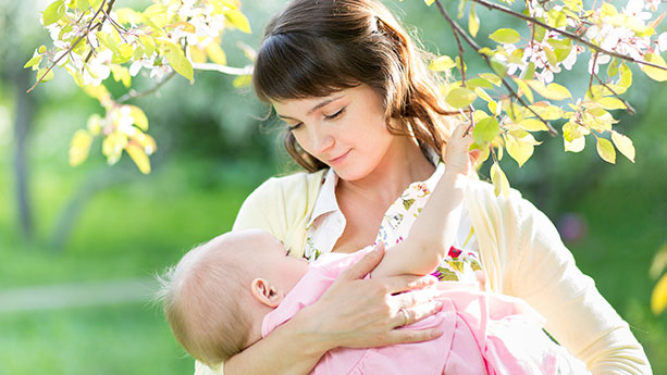 Woman breastfeeding under tree
