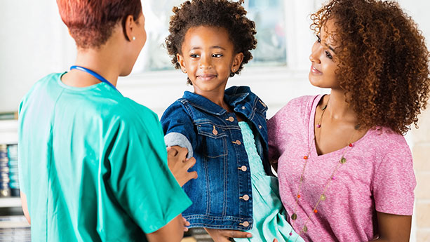 young african american child and mother talking to doctor