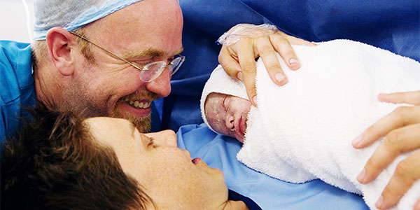 New parents holding baby after a c-section birth