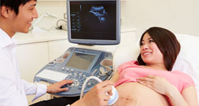 Pregnant Asian woman having ultrasound test