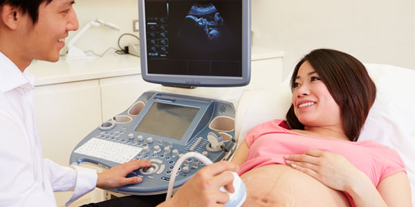 Pregnant Asian woman having ultrasound test