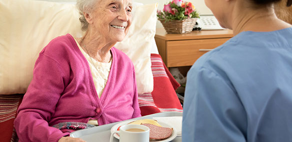 patient volunteer delivering food to elderly patient