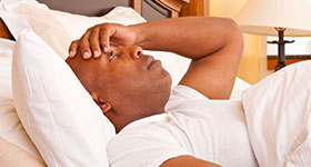African American man sleepless in bed