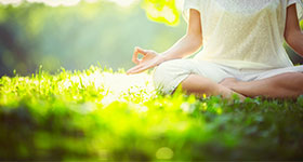 woman meditating in grass