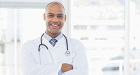 Confident ethnic male doctor smiling at camera