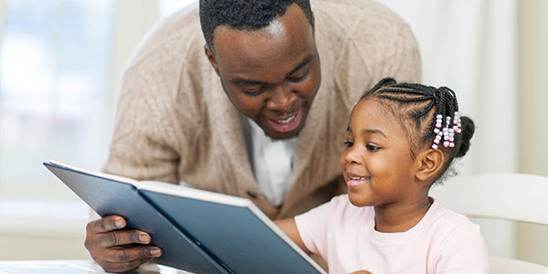 African American Father and daughter reading