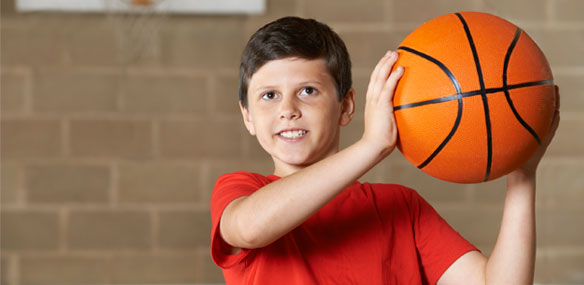 Boy holding basketball in gym