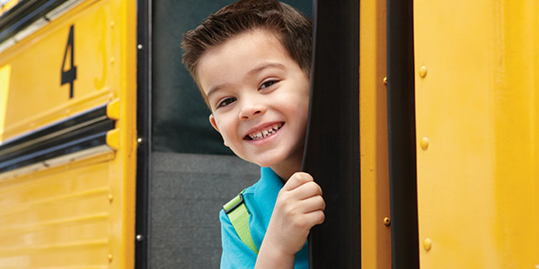 Little boy getting on school bus