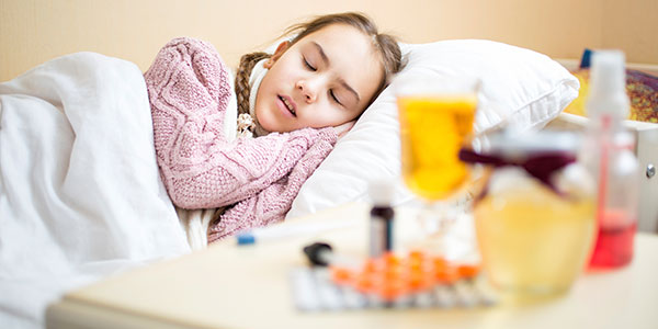 Sleeping girl with medicine on table