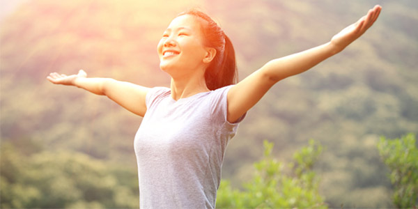 Happy young Asian woman on mountain top